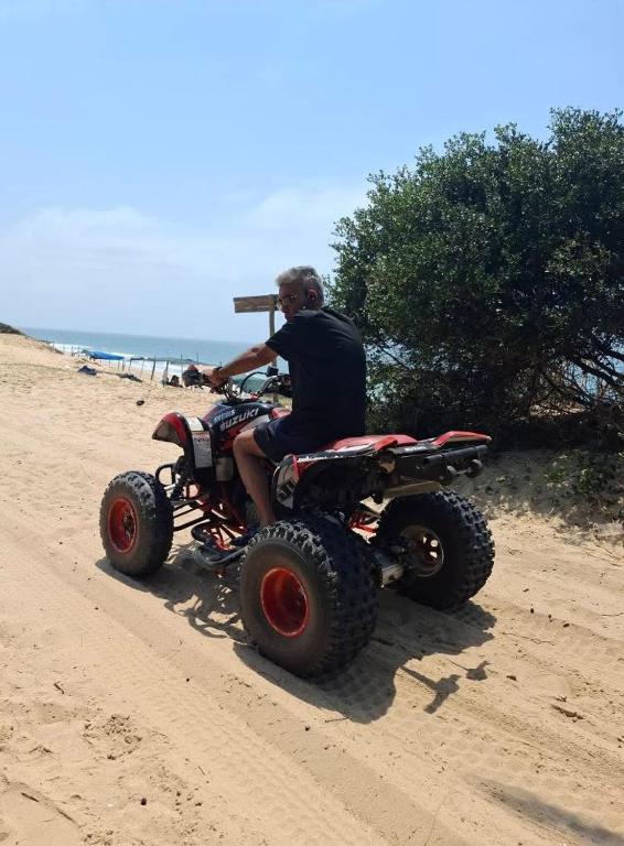 a man riding a four wheeler on the beach at Sombra de Macaneta in Marracuene
