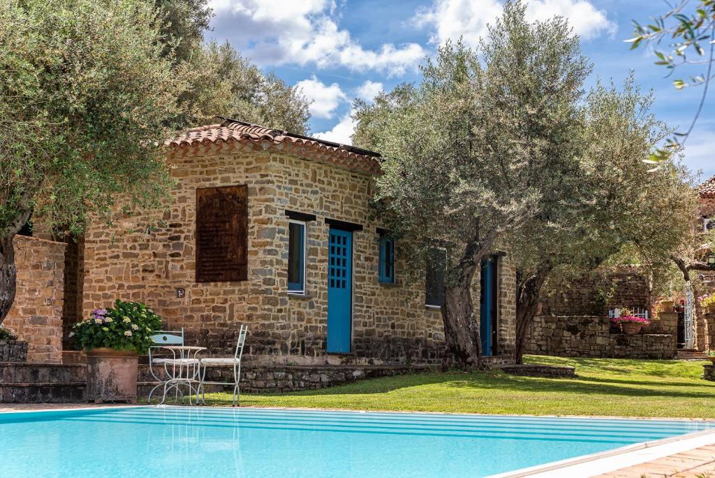 a house with a swimming pool in front of a building at Agriturismo Il Vecchio Casale in Vatolla