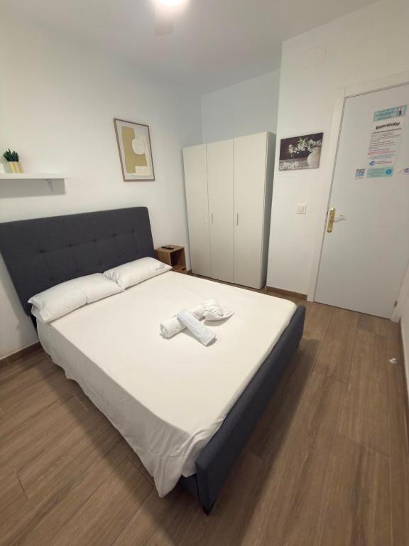 a bedroom with a large bed with a white sheet at Rooms Sincelejo in Madrid