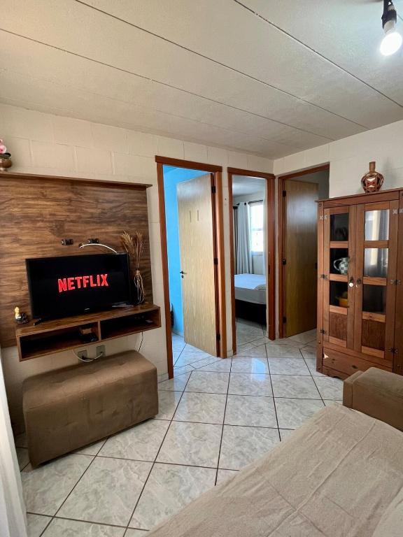 a bedroom with a bed and a tv on a wall at 09 - AP proximo do metrô, centro e rodoviaria, com ar condicionado e Wi-Fi in São Leopoldo