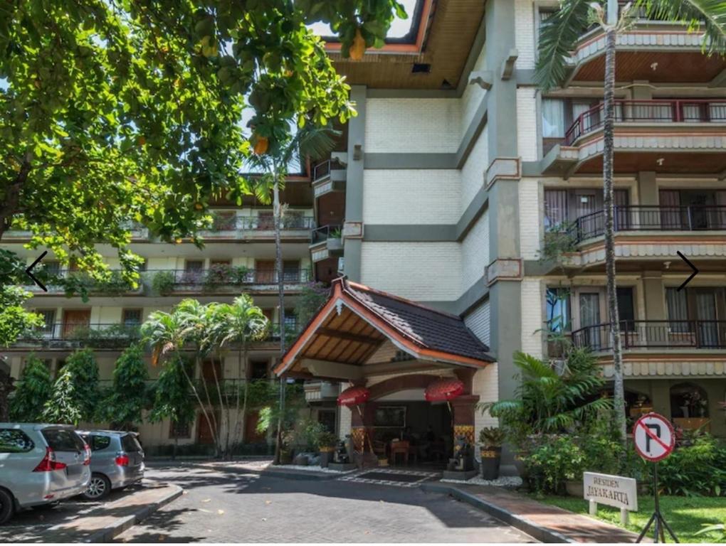 a building with cars parked in front of it at Club Bali Suite Legian in Legian