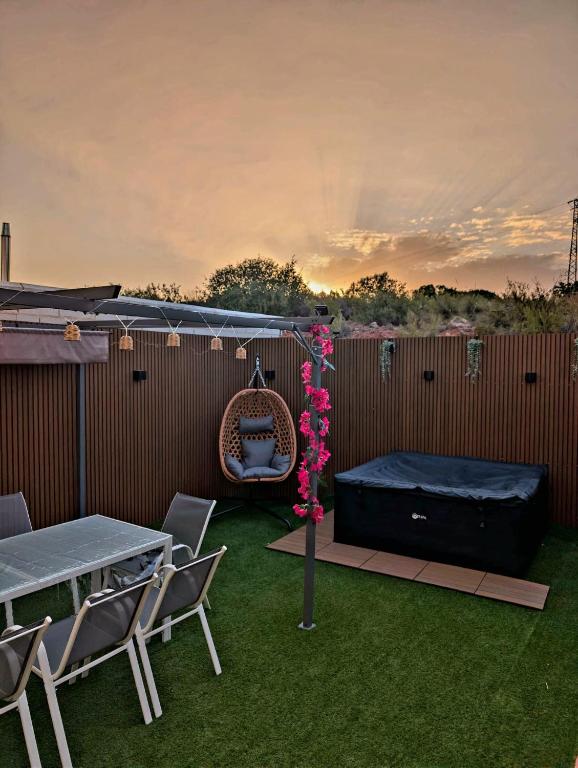 a patio with a table and chairs and a swing at Casa Ariño Ruidera in Ruidera