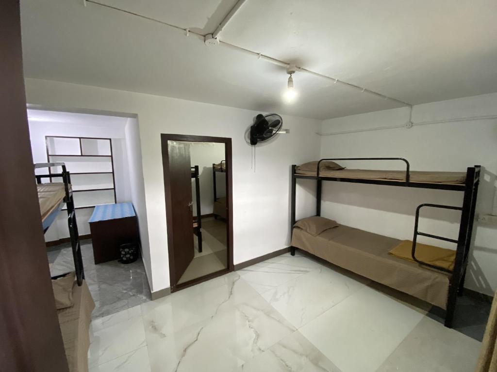 a room with two bunk beds and a mirror at Sleek Haven Dormitory in Meppādi