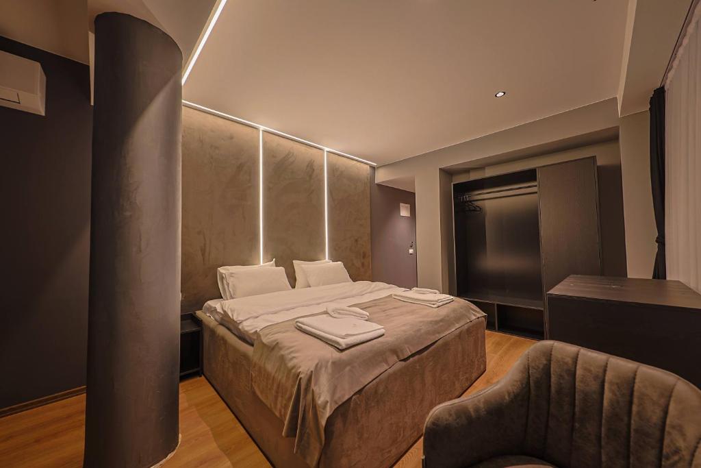 a hotel room with a bed and a chair at Hotel Impex in Peje