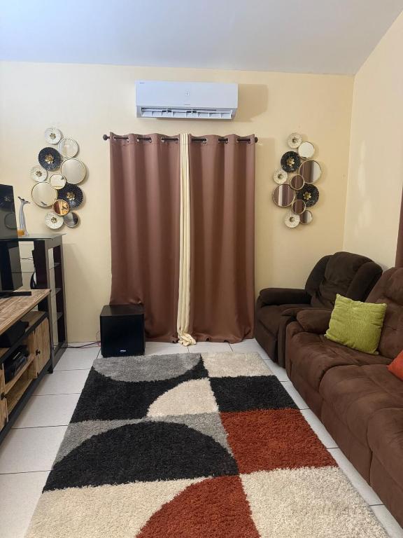 a living room with a couch and a rug at Bella Casa in Kingstown