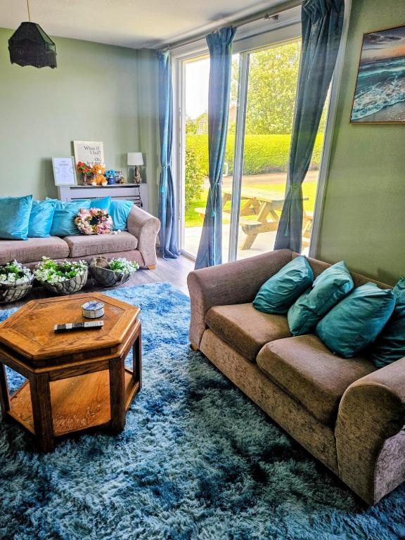 a living room with two couches and a coffee table at The Little Green Hideaway in Fivemiletown
