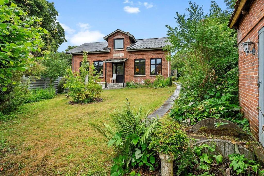 a brick house with a garden in front of it at 4025-Borre-Liselundvej-20 in Borre