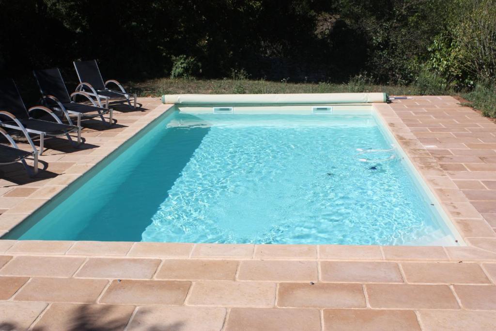 a small swimming pool with chairs in a backyard at Le Jardin Aux Lilas in Cadrieu