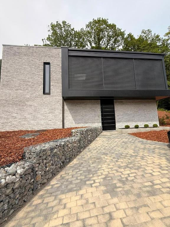 a house with a stone wall and a stone driveway at Cit'Art in Namur