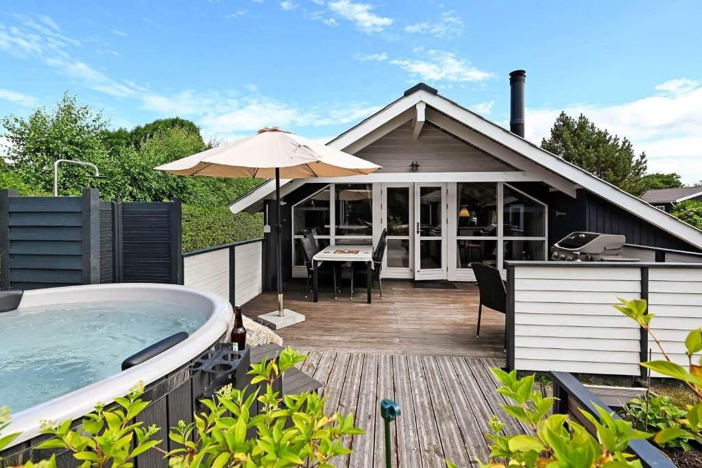 a hot tub sitting on a deck next to a house at C11267-Hemmet-Egernvej-12 in Henne Strand