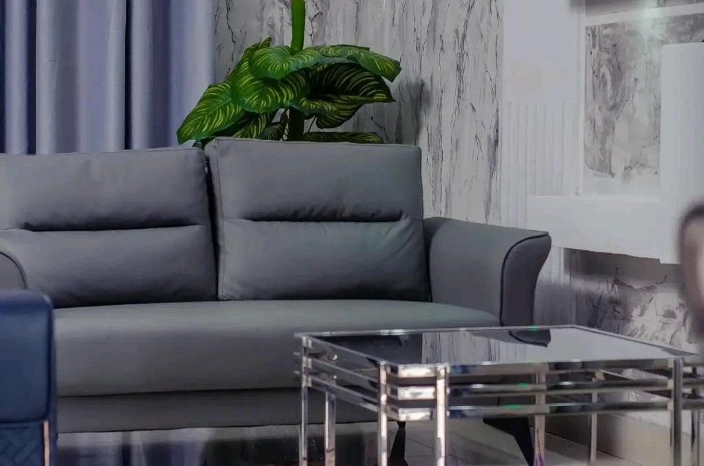 a living room with a couch and a glass coffee table at Skyline Guest House in Kinshasa