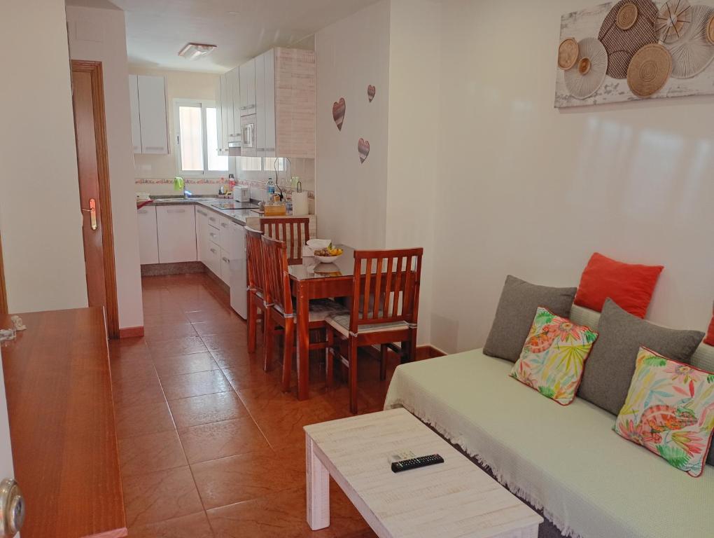a living room with a couch and a kitchen at Apartamento By Llu in Alcalá la Real