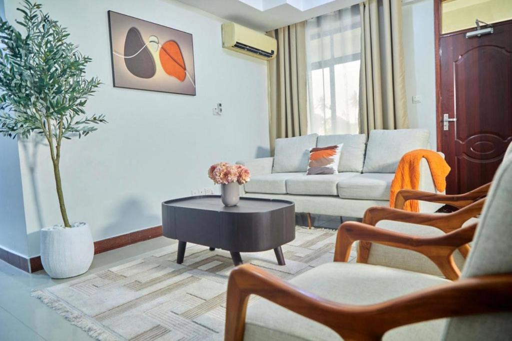 a living room with a couch and a table at LUXIRIOUS Homes in Dar es Salaam