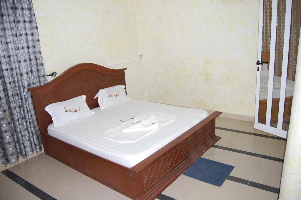 a bed in a room with two towels on it at Link Hotel in Lokossa