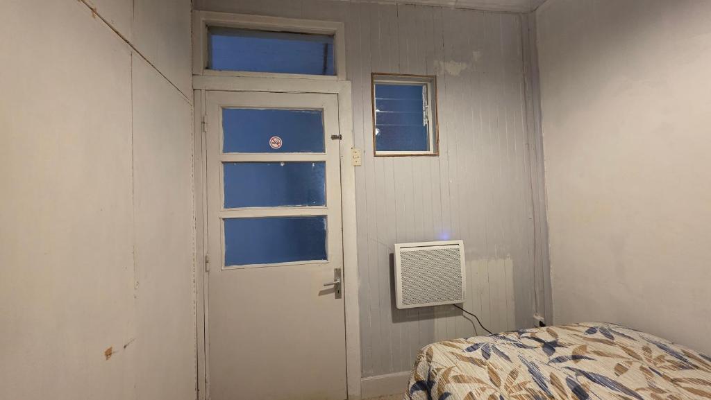 a room with a door and a monitor next to a bed at Alojamiento Centro de Punta Arenas in Punta Arenas