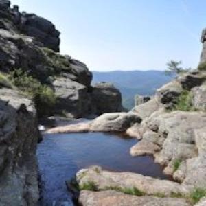a small pool of water between two rocks at GITE AUTOMNE in Le Soulié