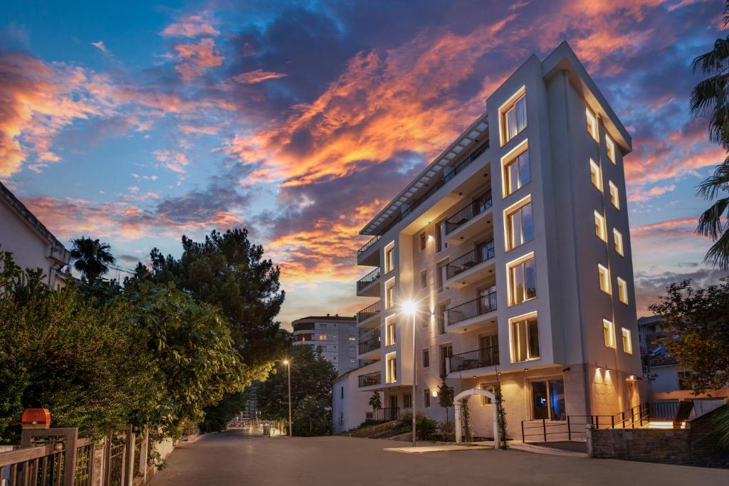 an apartment building with a sunset in the background at VELIERO Residence by Bracera in Lugovi
