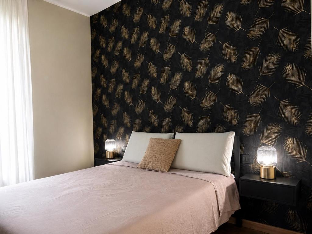 a bedroom with a bed and a wall with feathers at Favola Guesthouse Affittacamere in Nettuno