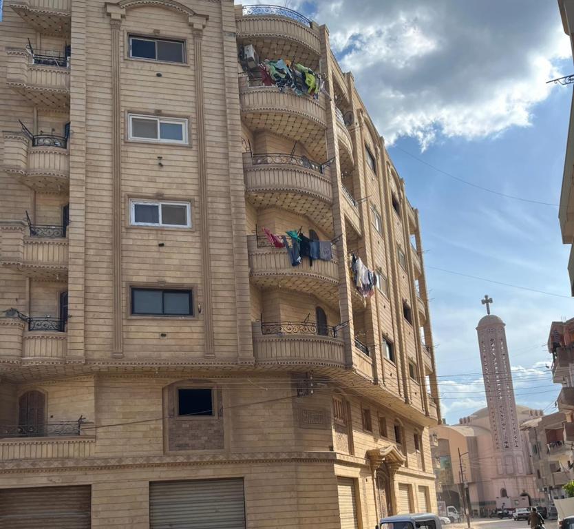 a tall building with balconies on the side of it at Your sweet house in Minshāt Şabrī