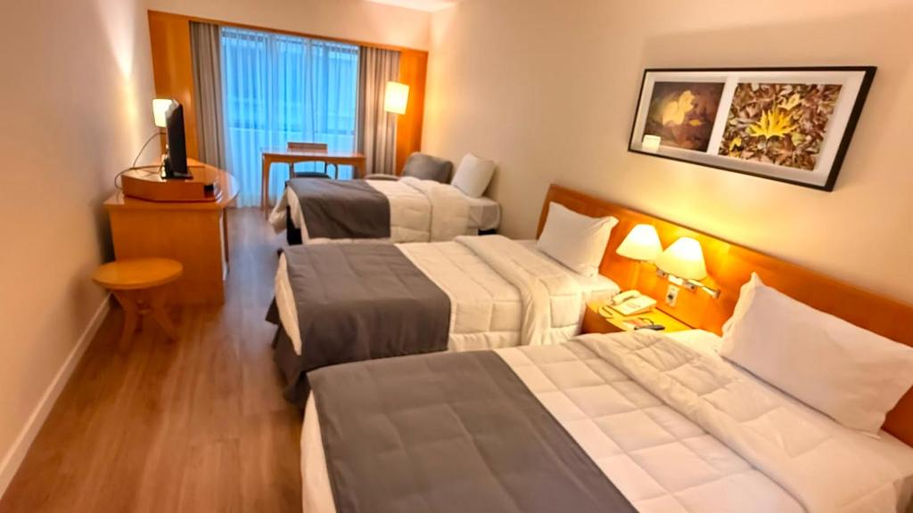 a hotel room with three beds in a room at Hotel & Residence Alphaville in Barueri