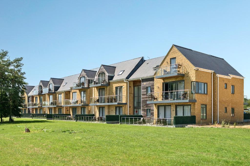 a large brick building with a lawn in front of it at Cotswolds Apartment 3 Sleeps 9 in Chipping Norton