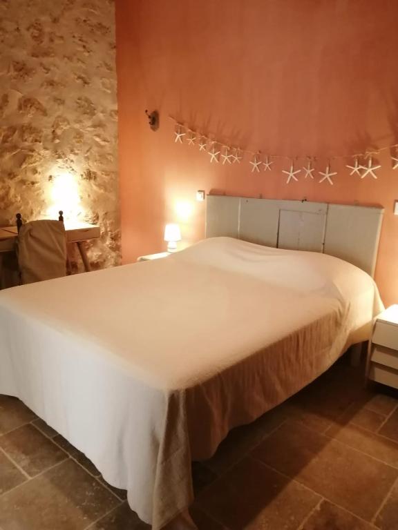 a bedroom with a large white bed in a room at Au coeur de Leucate in Leucate