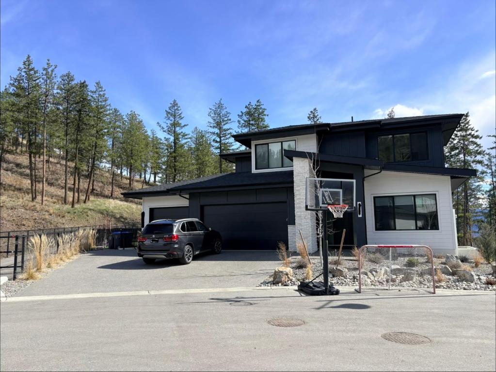 a house with a basketball hoop in a driveway at Upscale One Bedroom Suite in New Build in Kelowna