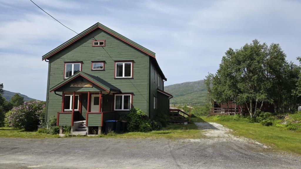 a green house on the side of a road at Skorovas Fjellstue in Namsskogan