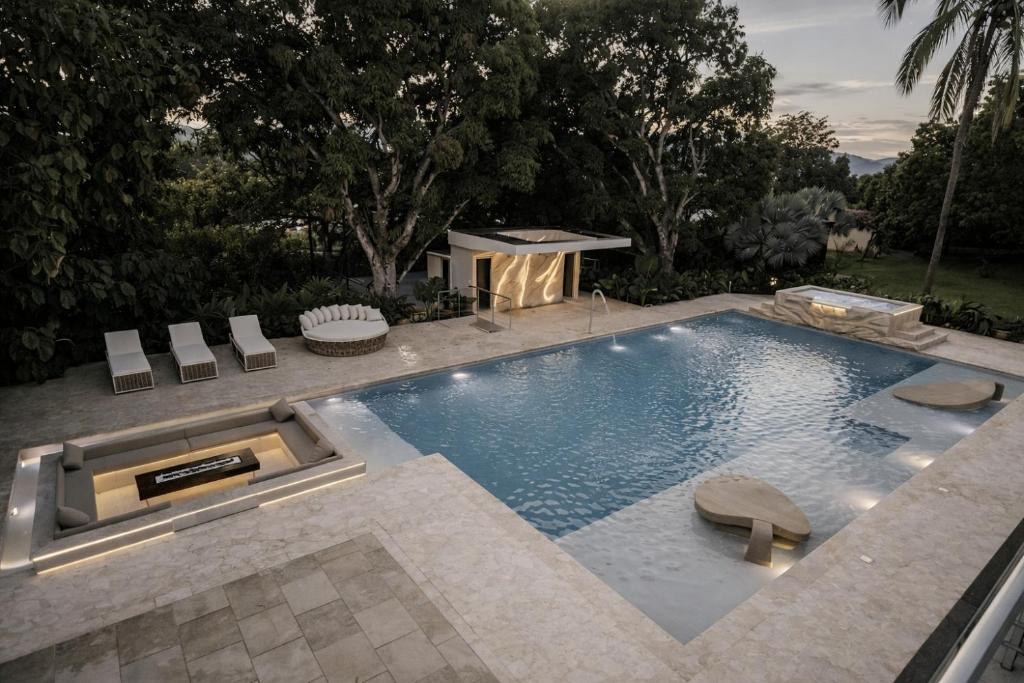a swimming pool with two chairs and a table at Finca Hotel Dubai in San Jerónimo