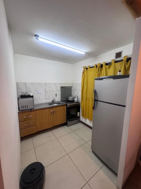 a small kitchen with a refrigerator and a sink at René Favaloro in Rincon de los Sauces