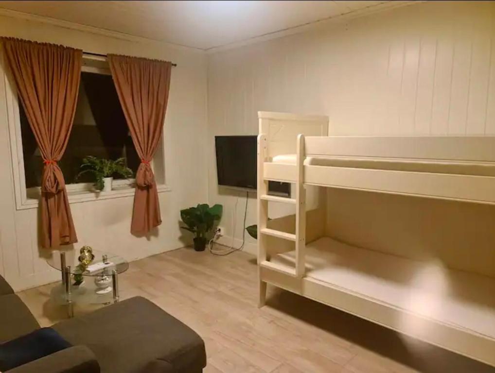 a living room with a bunk bed and a couch at Sentral leilighet Odda Trolltunga in Odda