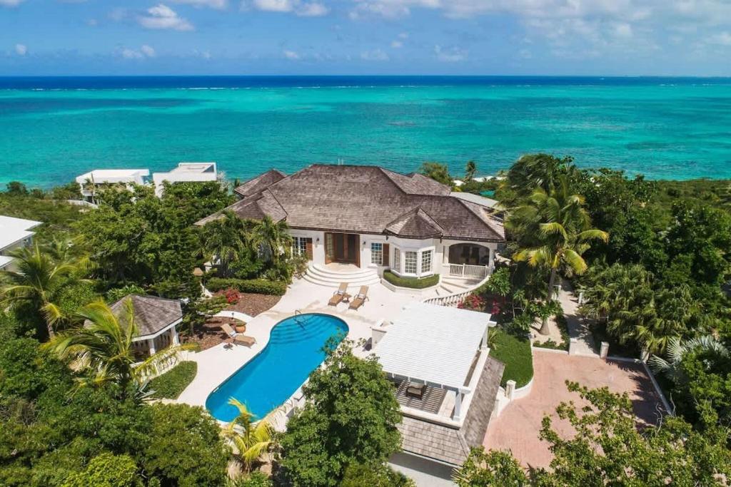 an aerial view of a house with a swimming pool and the ocean at Villa with Sea View in Providenciales