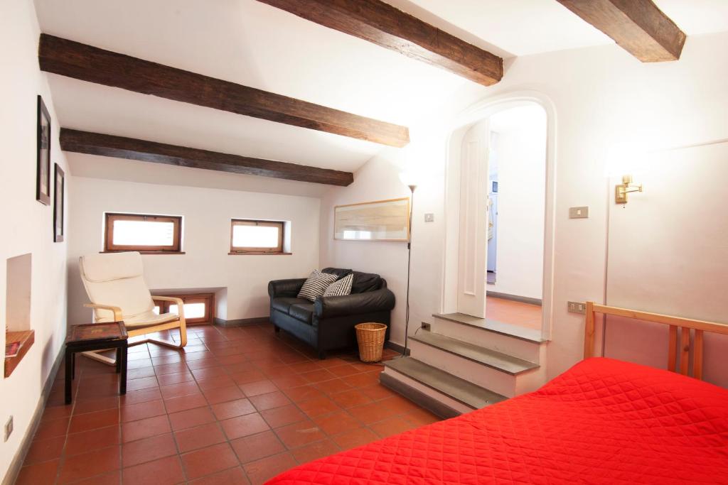 sypialnia z czerwonym łóżkiem i salon w obiekcie Riverside Apartment in Florence we Florencji