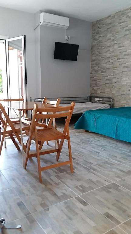 a room with a table and two chairs and a bed at Muretto House in Oreoi