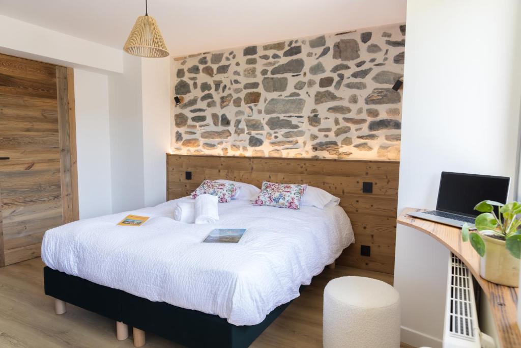 a bedroom with a bed and a laptop on a desk at Maison Serrioux in Cholonge