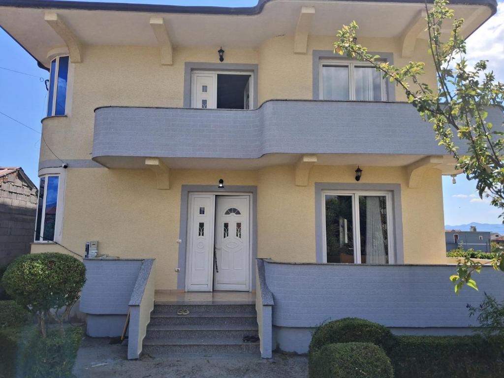 a yellow house with a white door at Villa Elezi in Culaj