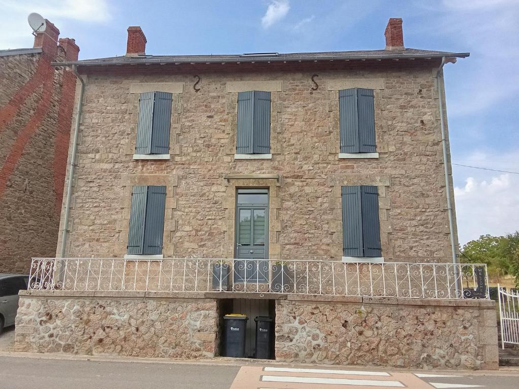 an old brick building with a balcony at Les lapins bleus in Saint-Sulpice-le-Dunois