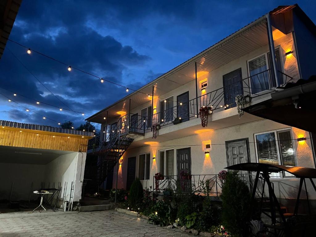 a white building with a balcony and a patio at Амир гостевой дом в Корумду in Korumdy