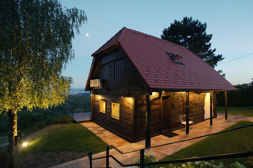 a small wooden cabin with a red roof at Lady Wine in Plešivica