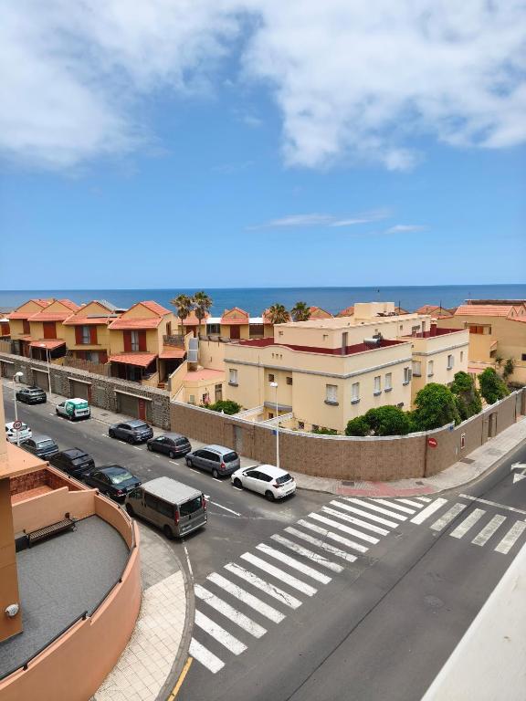 a view of a street with cars parked on the road at La Ola in El Médano
