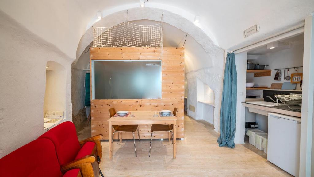 a living room with a table and a red couch at Rentbeat collection 3 historic center in Ostuni