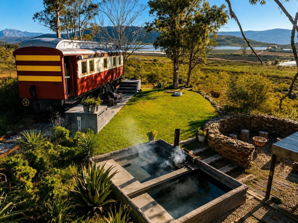 a train in a garden with a fountain at The Red Caboose Train Carriage in McGregor