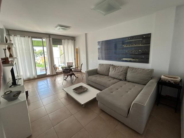 a living room with a couch and a table at Atico en Almadraba in Benicàssim