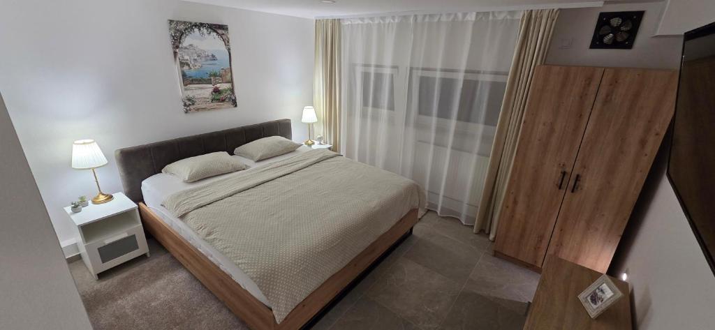 a small bedroom with a bed and a window at Melody Apartment Kutina in Kutina