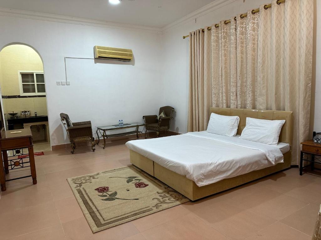 a bedroom with a bed and a desk in it at Simple Beach Stay 100m to Dahariz Beach Salalah in Salalah