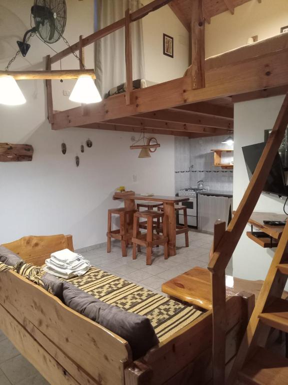 a room with a loft bed and a table at Cabañas LaMaria in Coronel Suárez