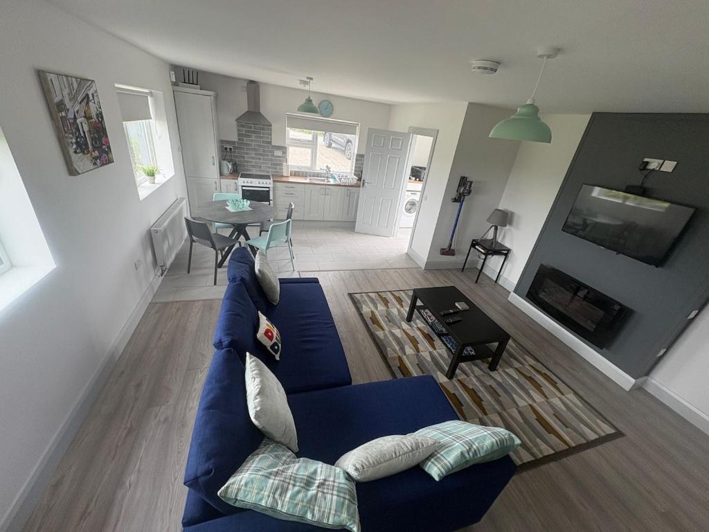 a living room with a blue couch and a table at Lar Na Cluaine in Kilmurry