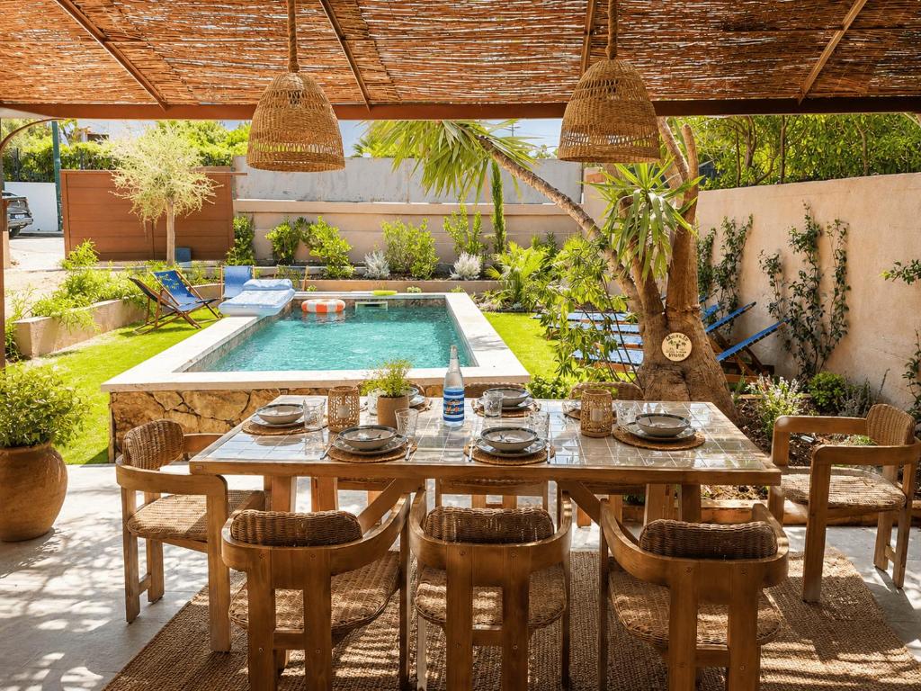 a table and chairs in a patio with a pool at Villa Mezzanotte Le Brusc 80m de la mer - Climatisation-Piscine-Parking in Six-Fours-les-Plages