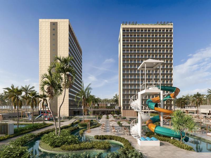 a water slide in a resort with two tall buildings at Apartamento Beach Resort in Salinópolis