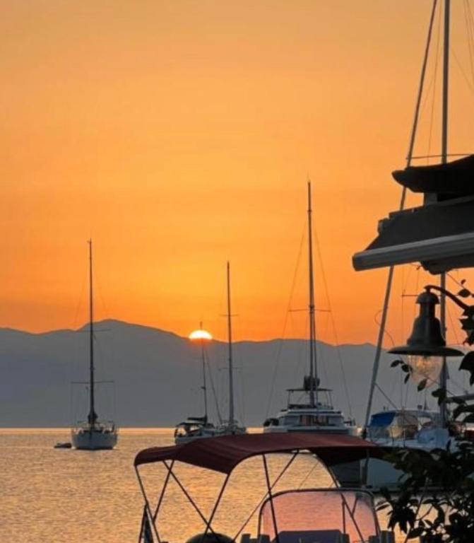 Eine Gruppe von Booten auf dem Wasser bei Sonnenuntergang in der Unterkunft Tolos Budget Rooms Loggos in Longós